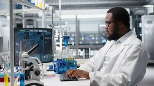 Man Working on Computer in a Modern Laboratory