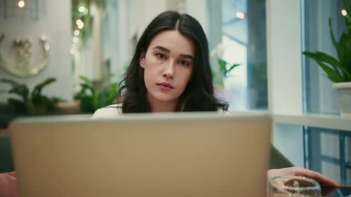 Young Woman Working on Laptop in Cafe