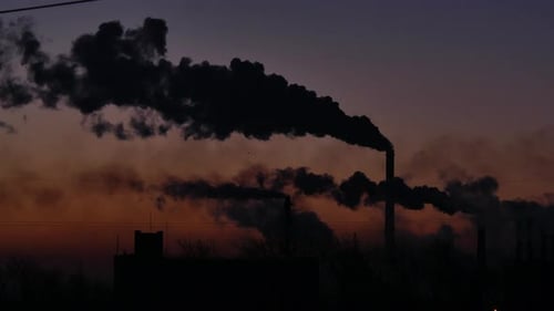 Smoke Billowing from Factory Smokestacks During Sunrise
