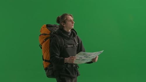 A Male Traveler Studies a Map of the Area While Hiking Linking to Signposts A Man Traveler with a
