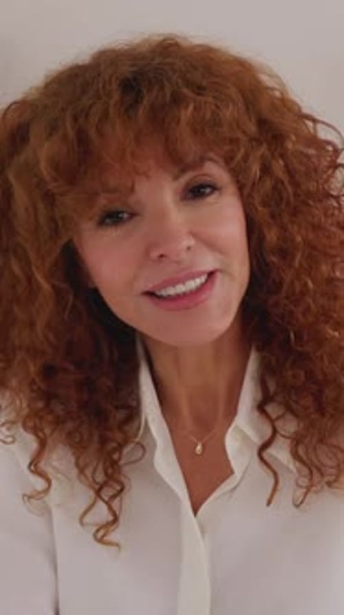 Smiling Woman with Red Curly Hair Talking Indoors