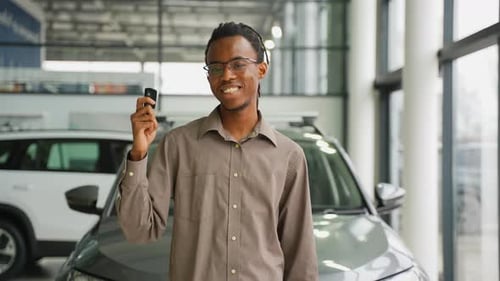 Young Adult Holding Car Keys in Showroom