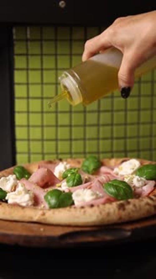 Adding Olive Oil to Fresh Pizza in Kitchen