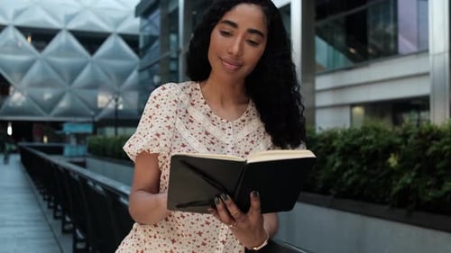 Young Woman Reads Book in Modern City Setting
