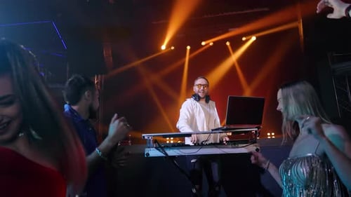 Musical DJ Playing Music at Nightclub Party with Dancing People Crowded Disco Club Zoom in Slowmo