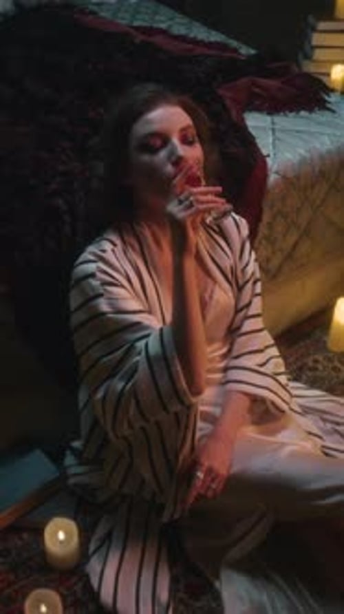 Vampire Woman Sipping Blood, Surrounded by Candlelight and Books