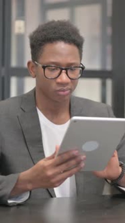 Vertical, African American Man Using Digital Tablet in Office