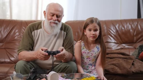 Grandfather and Granddaughter Playing Video Games at Home