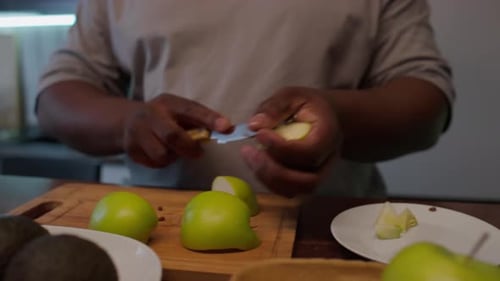 Close Up of Man Cutting Green Apple at Kitchen Table
