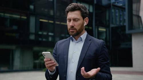 Businessman Using Phone for Video Call Outside Office