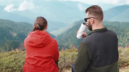 Tourists Man Woman Drinking Tea From Thermos Sitting Admiring Mountain Valley