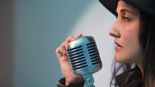 Close Side View of Singer in Black Hat with Vintage Microphone