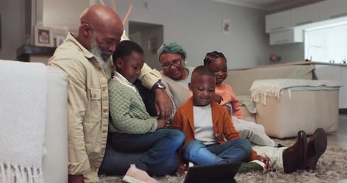 Grandparents Enjoying Time with Grandchildren Using Tablet Indoors