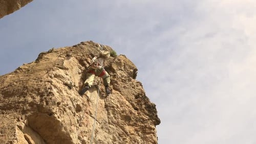 A Man is Climbing a Rock Wall