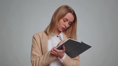 Woman Thinking and Writing in a Notebook
