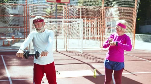 Active Seniors Exercising Together in a Cheerful Atmosphere at the Community Sports Court