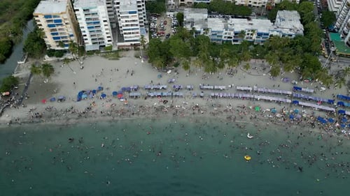 Aerial View of People Swimming at Rodadero Beach. Crowded Day. Descending Shot