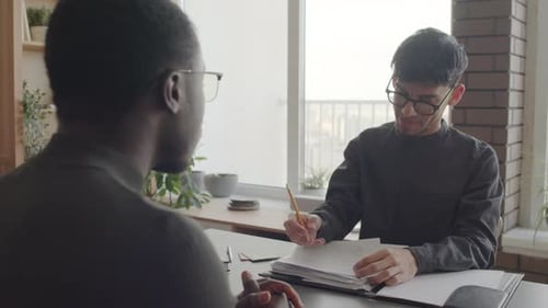 Two Young Adults Meeting and Taking Notes Together