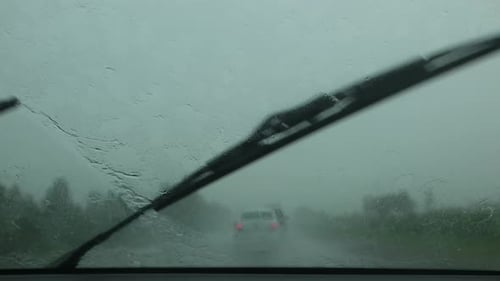 Im Auto, um bei starkem Regen zu fahren, reinigen Scheibenwischer das Windschutzscheibenglas