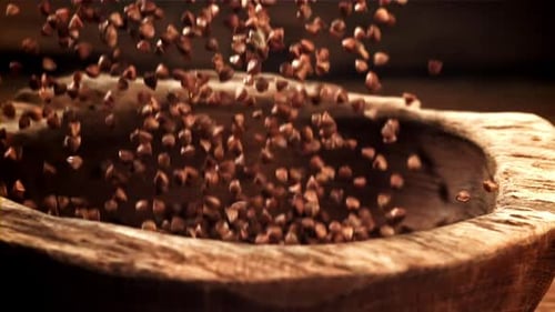 Buckwheat Grains Falling into Rustic Wooden Bowl