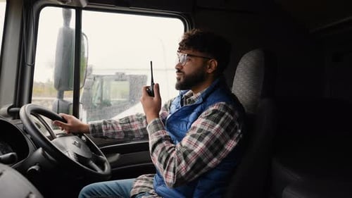 Truck Driver Communicating Using a Walkie Talkie in Right Hand Drive Car