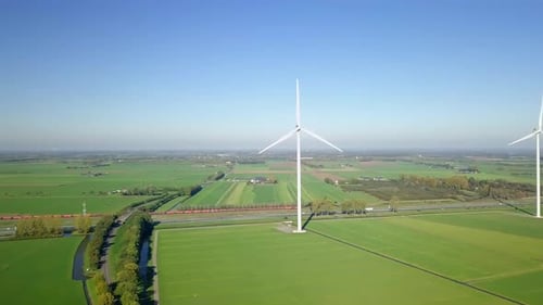 Luftbild einer Drohne auf dem ländlichen Ackerland, wenn ein Güterzug in den Niederlanden, Europa vorbeifährt