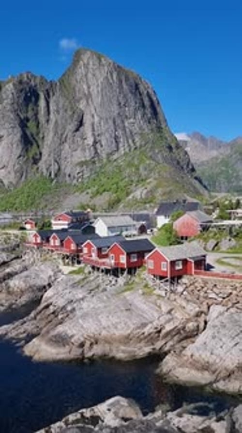 Stunning Coastal Village in Norway Lofoten with Traditional Red Cabins Nestled Against Mountains
