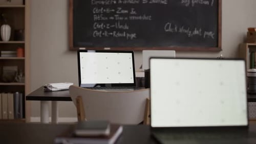 Modern Classroom Workspace with Laptops and Chalkboard