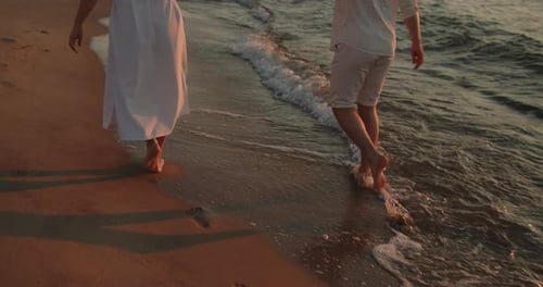 Young Loving Couple Enjoying Relaxing Sunset Walk on the Beach