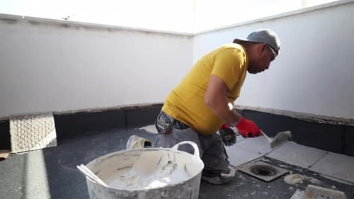 Man lays tile on rooftop terrace