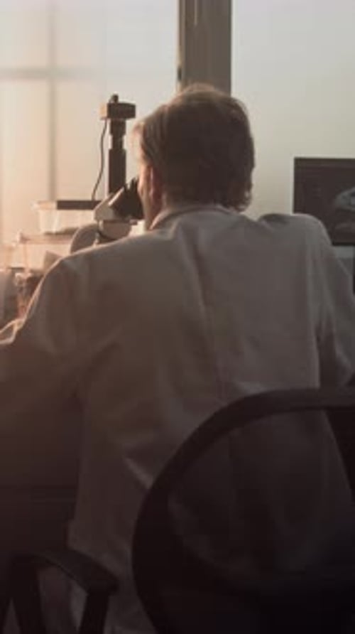 Scientist Using Microscope in Lab Workplace Setting
