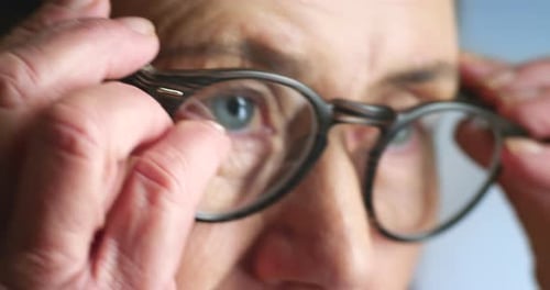 Senior Adult Putting On Their Eyeglasses Close-Up