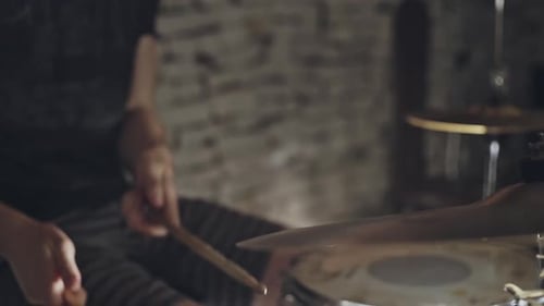 Drummer in a Rock Band Playing the Drums and Cymbals with Drumsticks in a Close Up Cropped View of