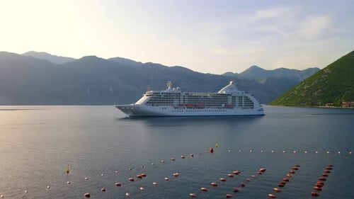 The Drone Captures a Stunning Aerial View of a White Cruise Ship Leaving the BokaKotor Bay in