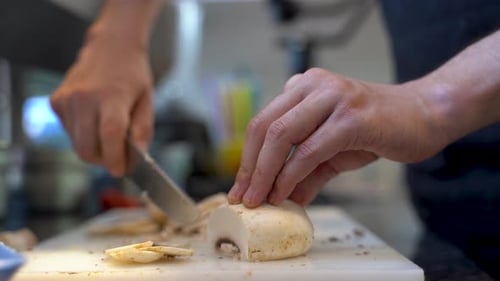 Close up of hand cutting mushrooms in the kitchen 4K