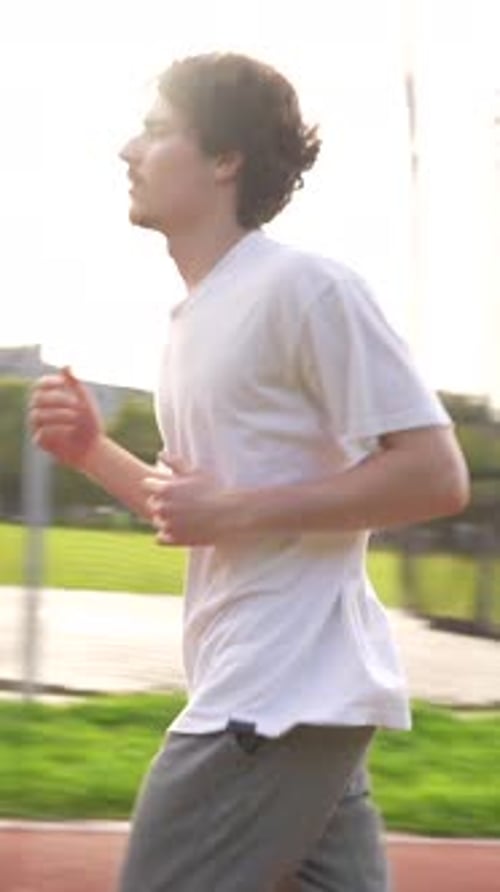 Young Adult Running on Red Track Outdoors