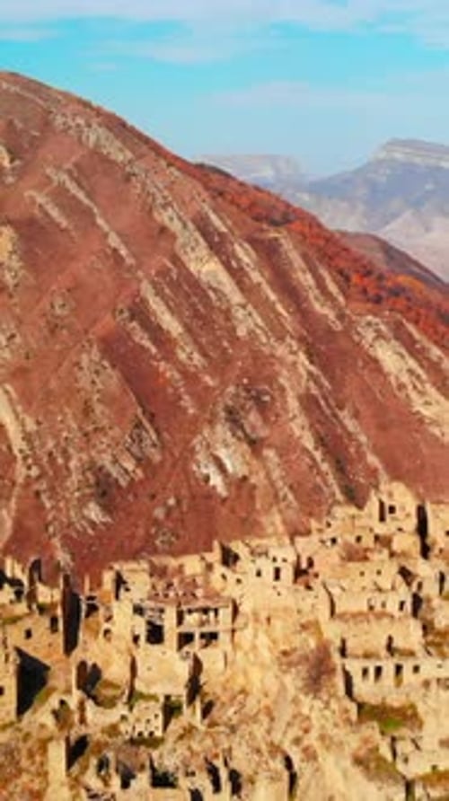 Cliffside Settlement with Sunlit Adobe Facades Clinging to Rugged Mountain Face and Winding Pathways
