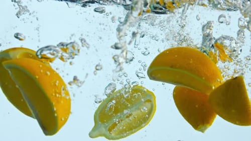 Bright Yellow Lemon Slices Plunge into Water