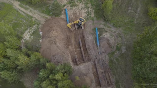 Excavator Digging Trenches in Rural Landscape