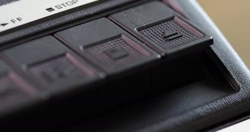 Die Auswurftaste eines alten Vintage-Kassettenspielers wird gedrückt (Makro)