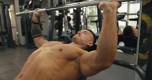 Athletic Caucasian Man Swings His Arms While Lifting a Barbell in the Gym Active Sports and Lifting