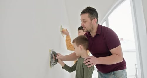 Father and Sons Smoothing Wall in Home