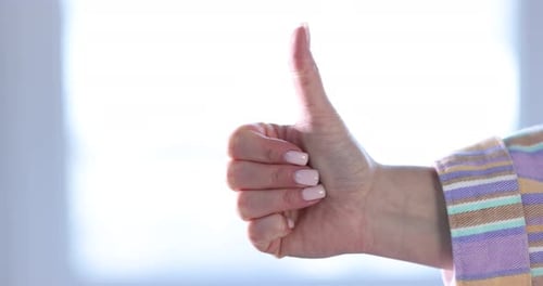 Woman's Hand Giving a Thumbs Up Gesture
