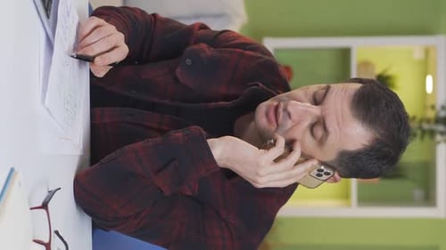 Man Talking on Phone While Working at Desk
