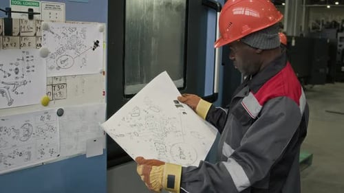 Ingénieur d'usine étudiant le dessin d'assemblage