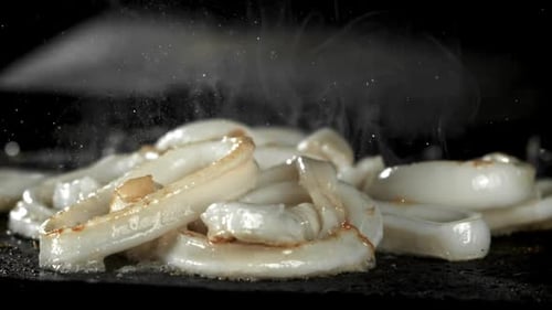 Squid Sizzling on Flat Grill in Close Up