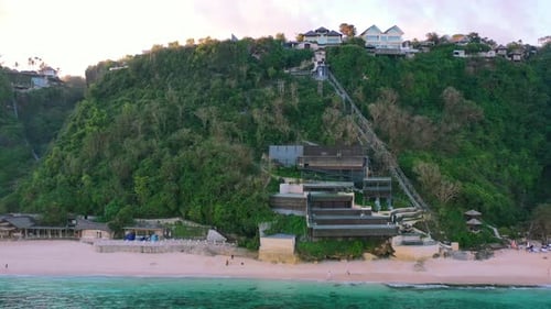 aerial of beachfront homes on cliffs of Uluwatu in Bali Indonesia during sunset