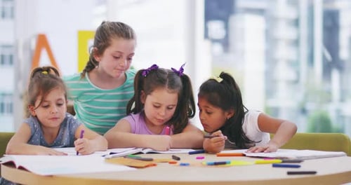 Young Girls Drawing Together at School Table