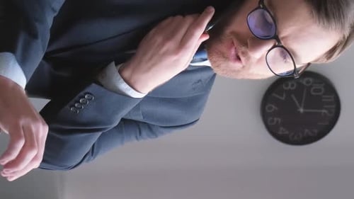 Man Talking on Phone at Desk in Office
