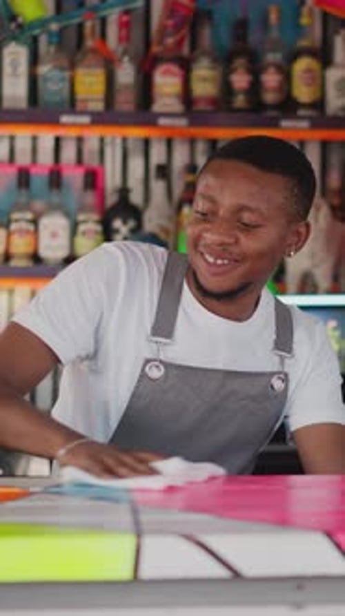 Positive Barman Wipes Countertop in Bar